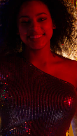 Vertical-Video-Of-Young-Woman-In-Nightclub-Bar-Or-Disco-Dancing-With-Sparkling-Lights-In-Background-5